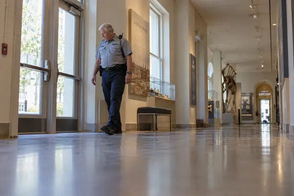 Illustrative private security work in St Louis, Missouri: Older male officer checking museum emergency-exit access