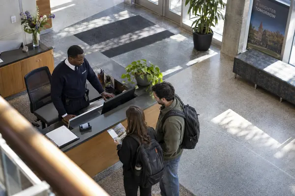 Illustrative private security work in Columbus, Ohio: Black male officer monitoring university lobby visitors