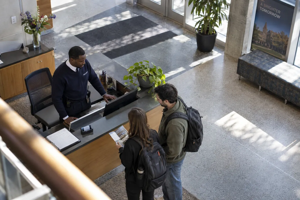 Illustrative private security work in Columbus, Ohio: Black male officer monitoring university lobby visitors